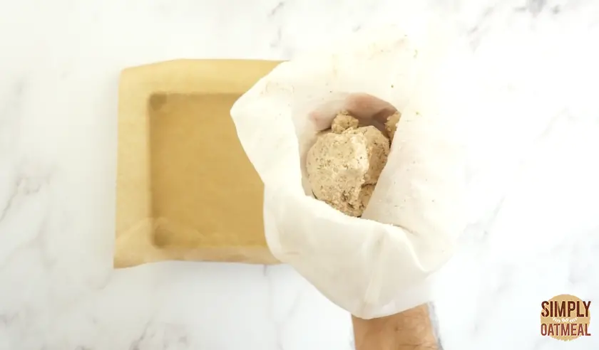 Wet almond pulp remains in the nut milk bag after straining all of the almond milk.