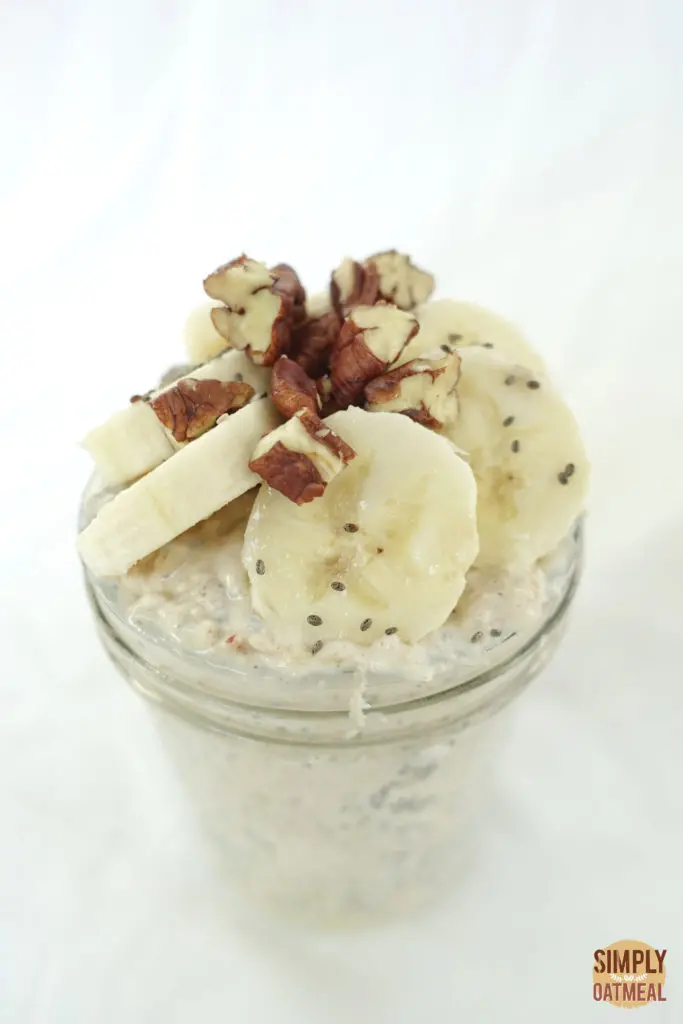 One serving of apple and banana overnight oats in a tall glass container.
