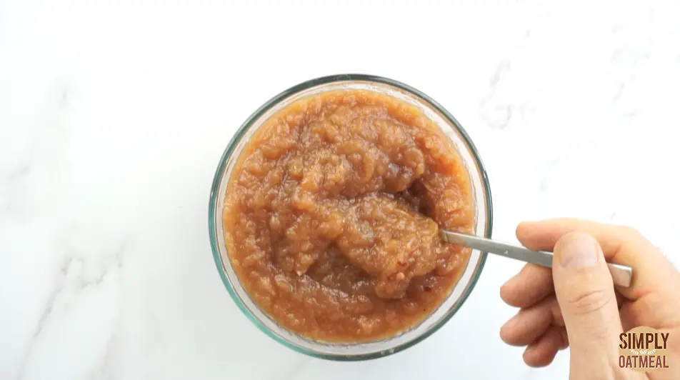 Apple butter in a glass bowl deep golden brown color apple butter inside a glass bowl.