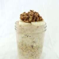 One serving of apple crumble overnight oats in a tall mason jar.