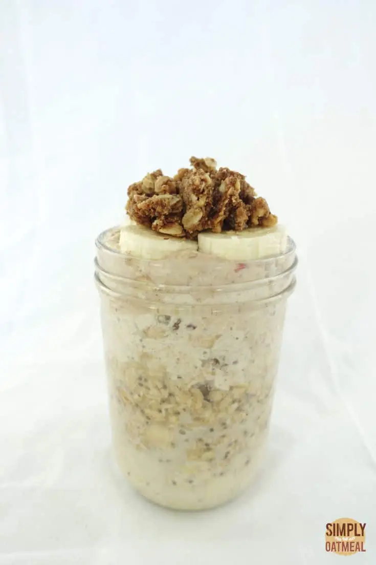 One serving of apple crumble overnight oats in a tall mason jar.