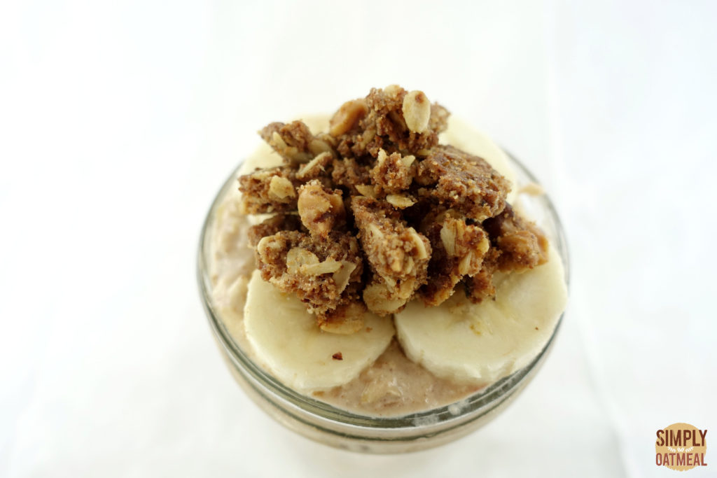 The overnight oats are topped with crunchy crumble topping and sliced bananas