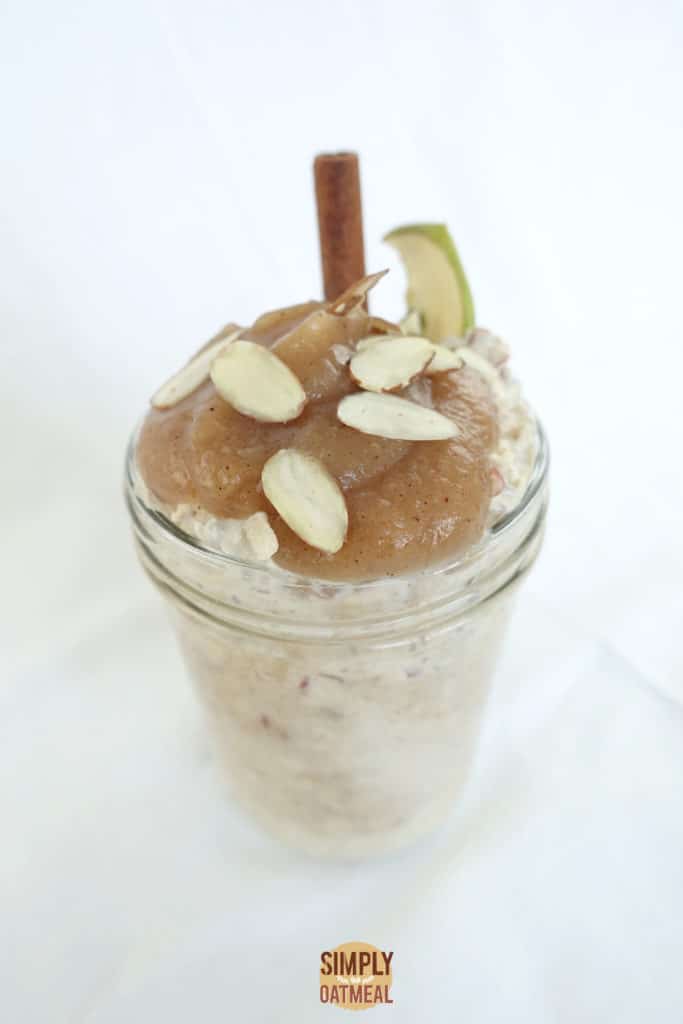 Singel serving of applesauce overnight oats topped with homemade applesauce, sliced almonds and dried apple chip.