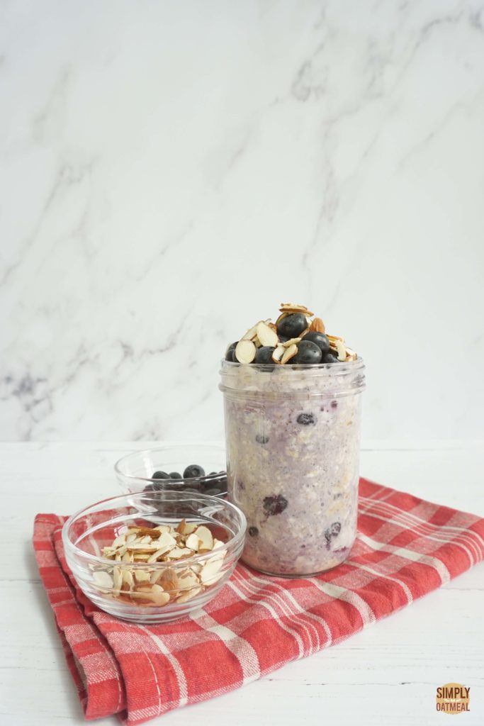 Blueberry almond overnight oats in a mason jar. The oatmeal is garnished with fresh blueberries and sliced almonds.