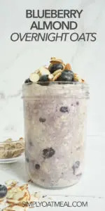 Single portion of blueberry almond overnight oats in a tall glass jar. The oatmeal is topped with almonds and fresh blueberries.