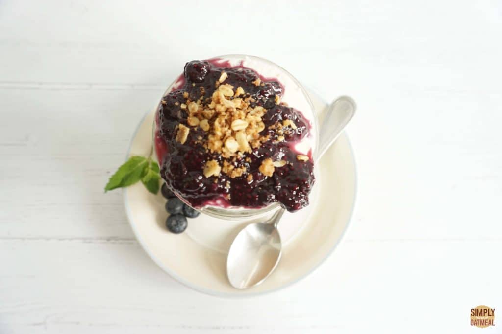 Blueberry cheesecake overnight oats served in a bowl and topped with homemade blueberry-chia jam