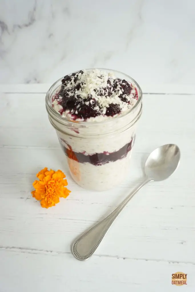 blueberry coconut overnight oats topped with blueberry jam and toasted coconut.