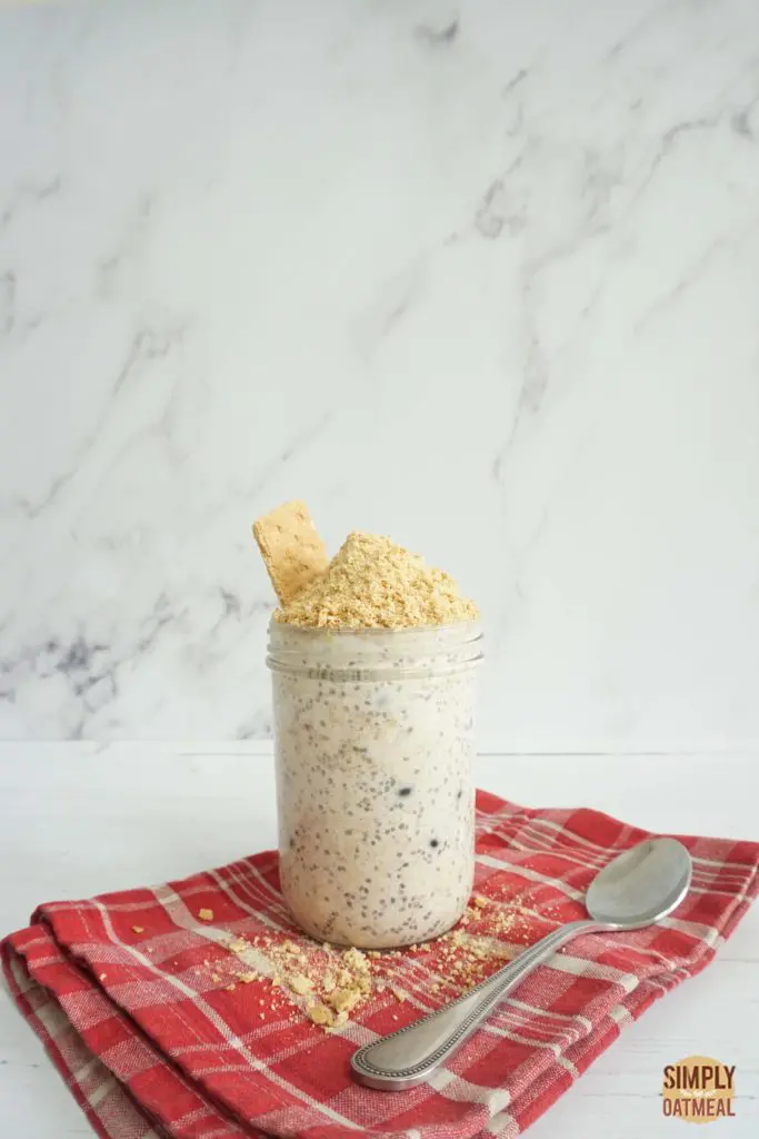 Blueberry Greek yogurt overnight oats in a tall mason jar with a spoon on the side