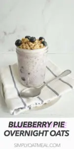 Blueberry pie overnight oats in a glass jar with a spoon on the side.