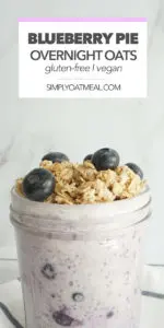 Serving of blueberry pie overnight oats in a glass bowl with fresh blueberries and crunchy pie topping