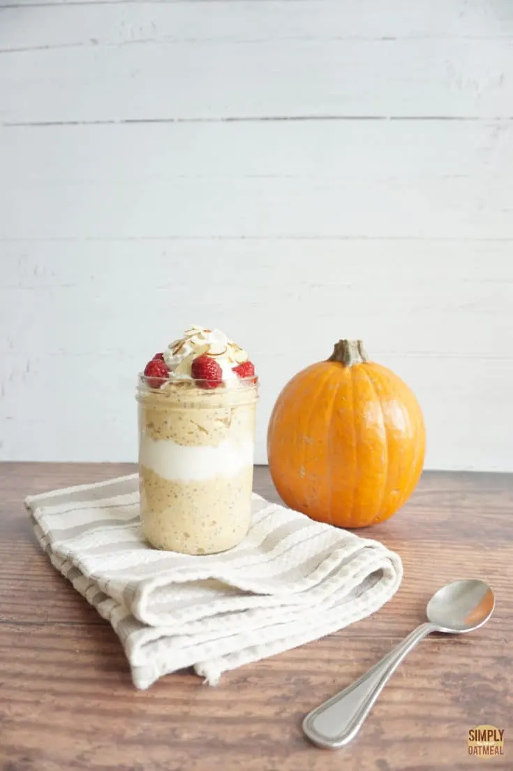 Pumpkin cheesecake overnight oats in a jar. Small sugar pie pumpkin in the background.