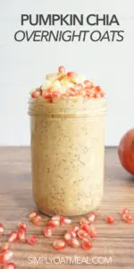 Pumpkin chia overnight oats served in tall glass jar. Oatmeal toppings include cubed apple and pomegranate seeds