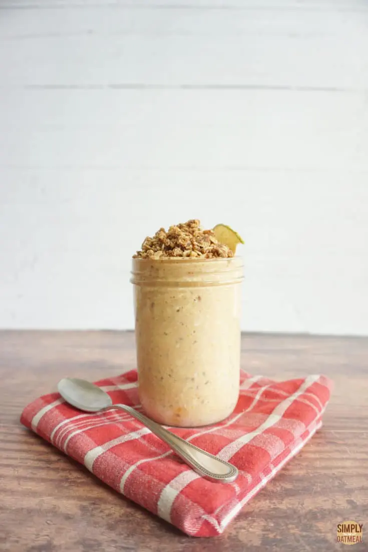 Pumpkin spice overnight oats in a glass container with a spoon on the side