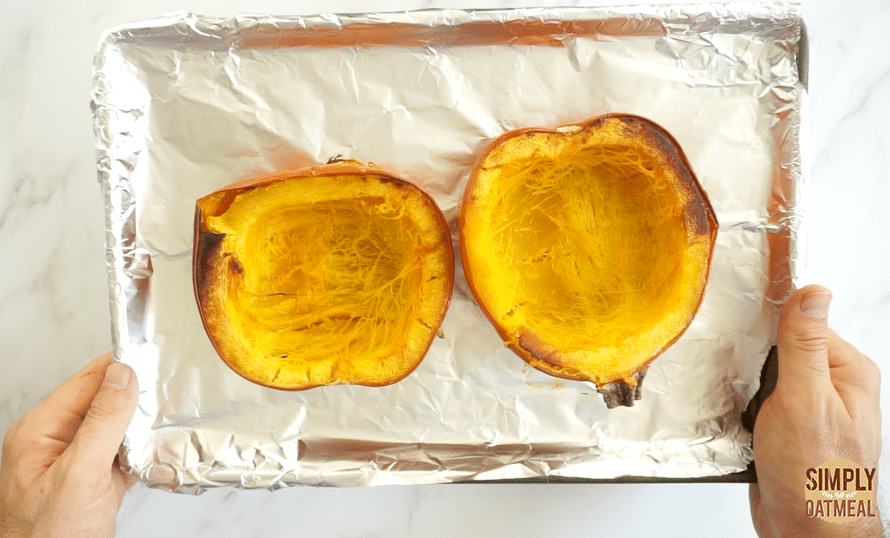 roasted pumpkin halves in the oven on a baking sheet with flesh side down