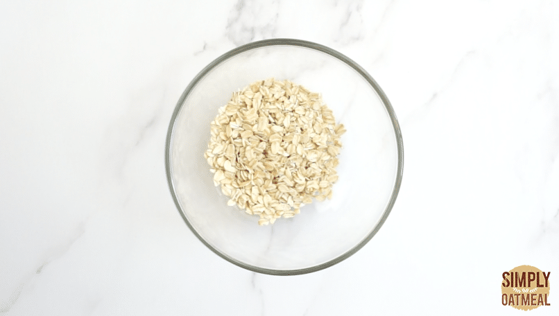 Rolled oats inside a glass bowl to make oatmeal crumble topping. Add the dry ingredients and then work the butter into pea-sized crumbles.