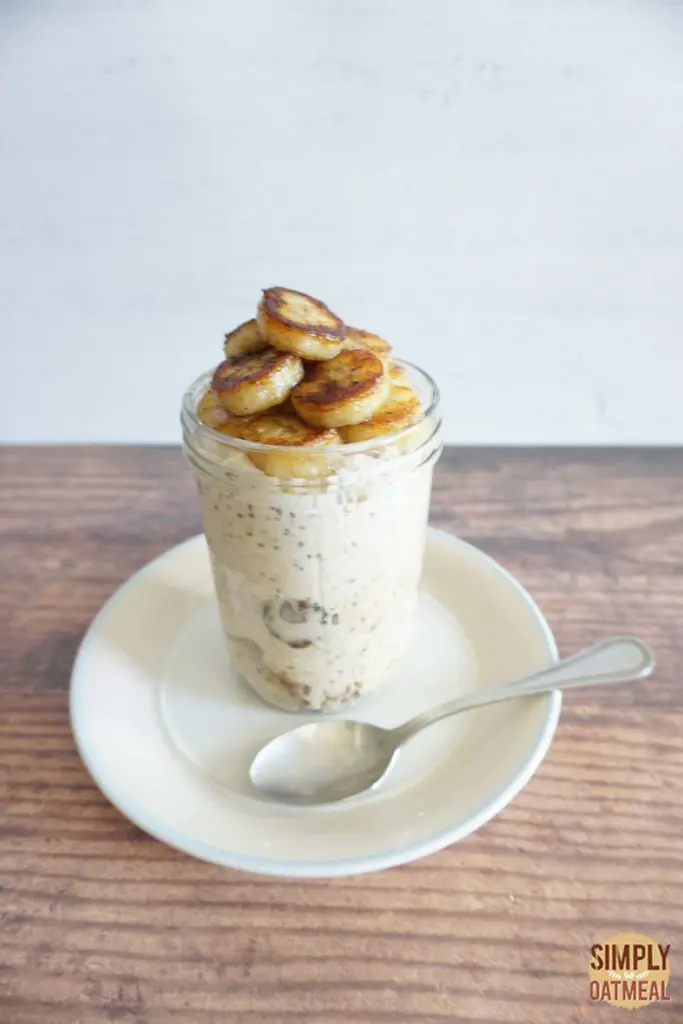 Banana foster overnight oats served with a small plate and spoon on the side.