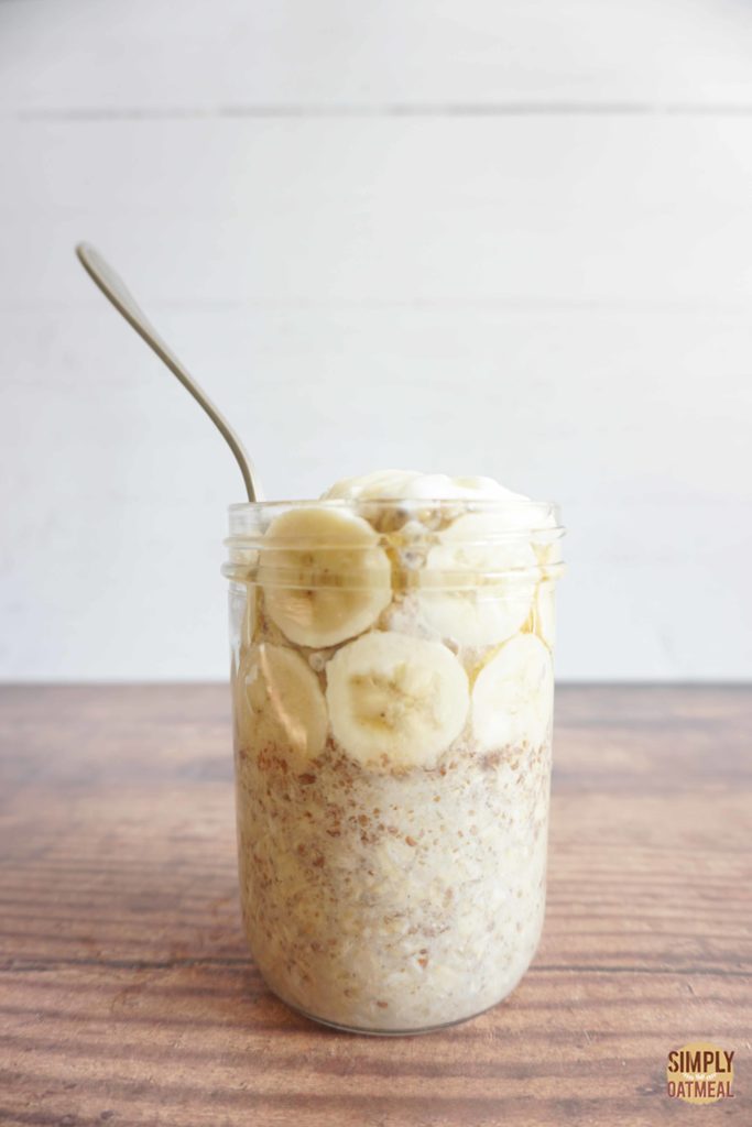 One serving of banana honey in an overnight oats container with a spoon sticking out