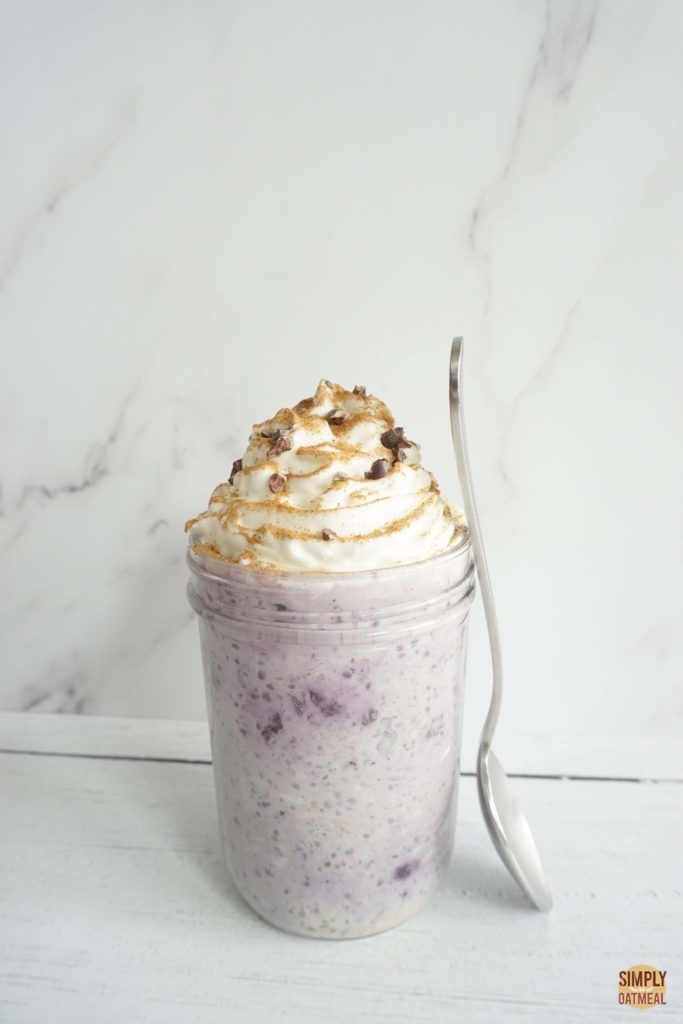 Single serving of blueberry chia overnight oats. The oatmeal looks purple because frozen berries bled color into the creamy liquid.