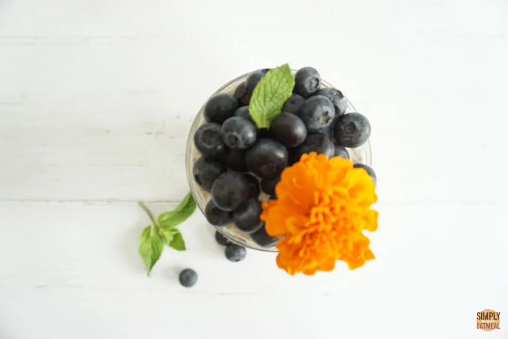 Blueberry muffin overnight oatmeal with fresh blueberries Blueberry muffin overnight oatmeal topped with fresh blueberries and an edible flower.