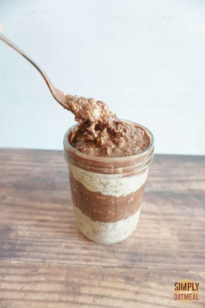 Spoon scooping into a bowl of chocolate peanut butter banana overnight oats