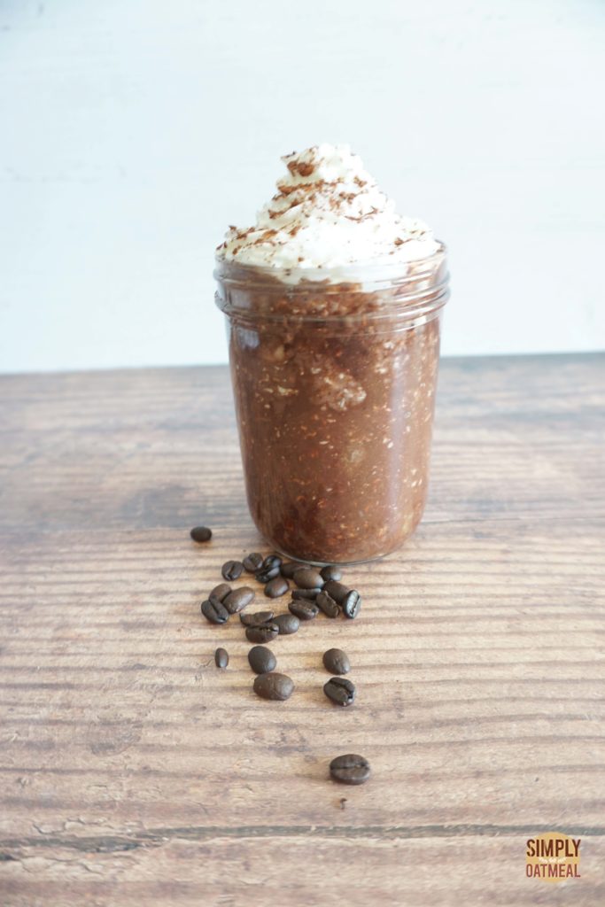 Mocha banana overnight oats topped with whipped cream, cocoa nibs and shaved chocolate