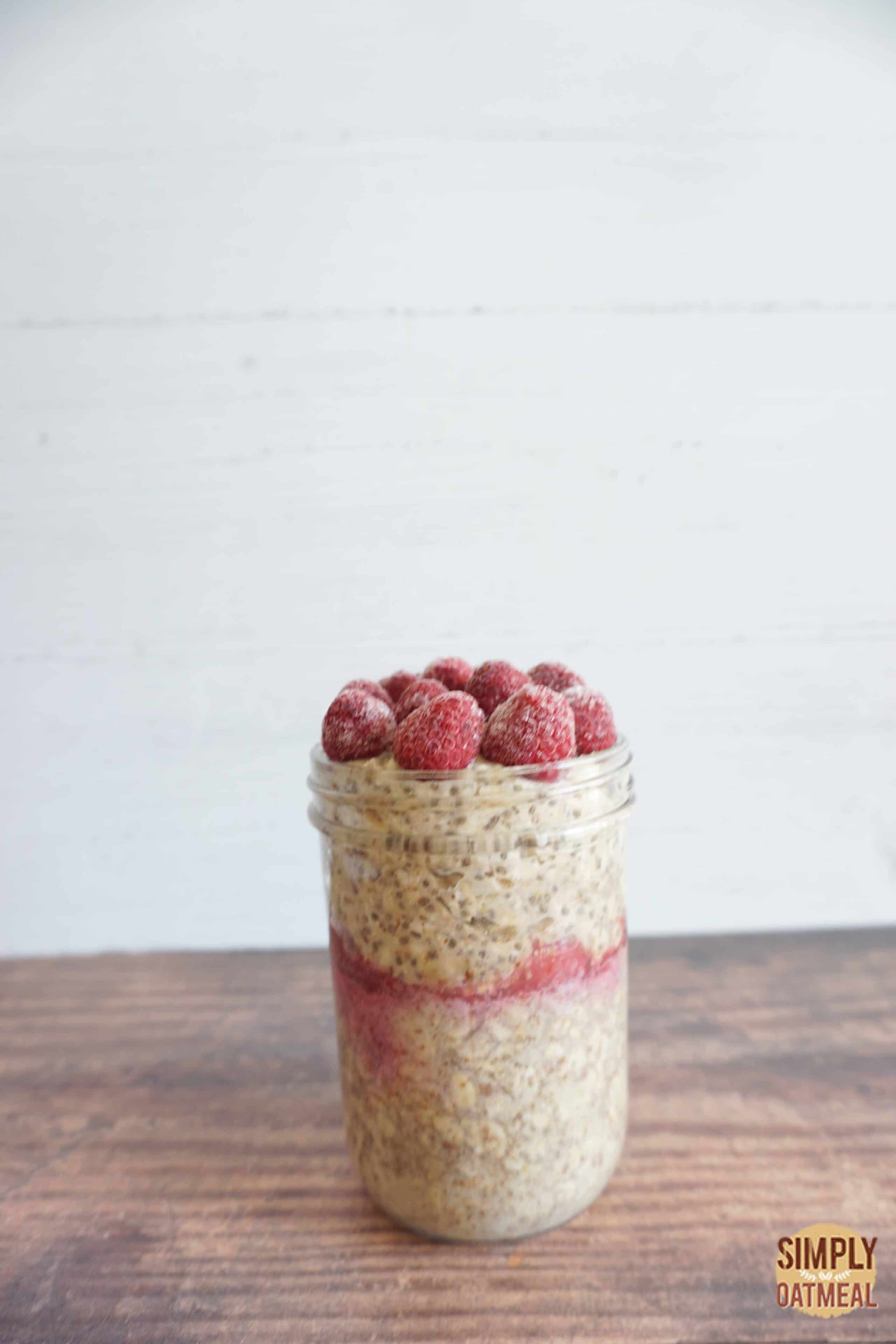 One serving of raspberry banana overnight oats in a mason jar.
