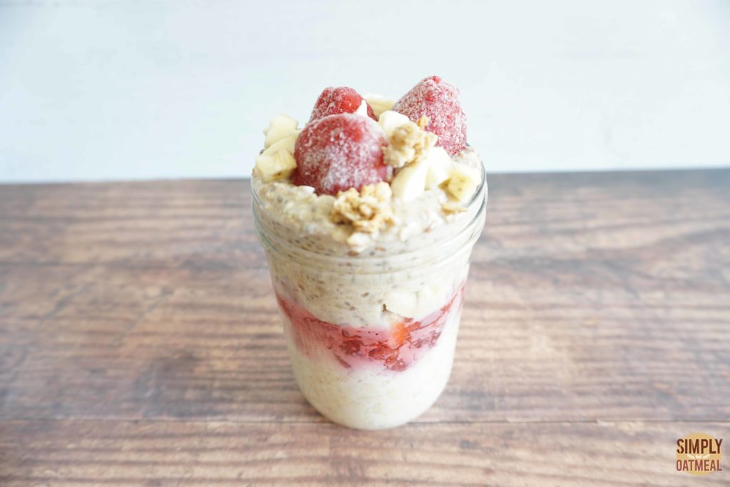 Serving of strawberry banana overnight oats with fresh strawberries and granola clusters