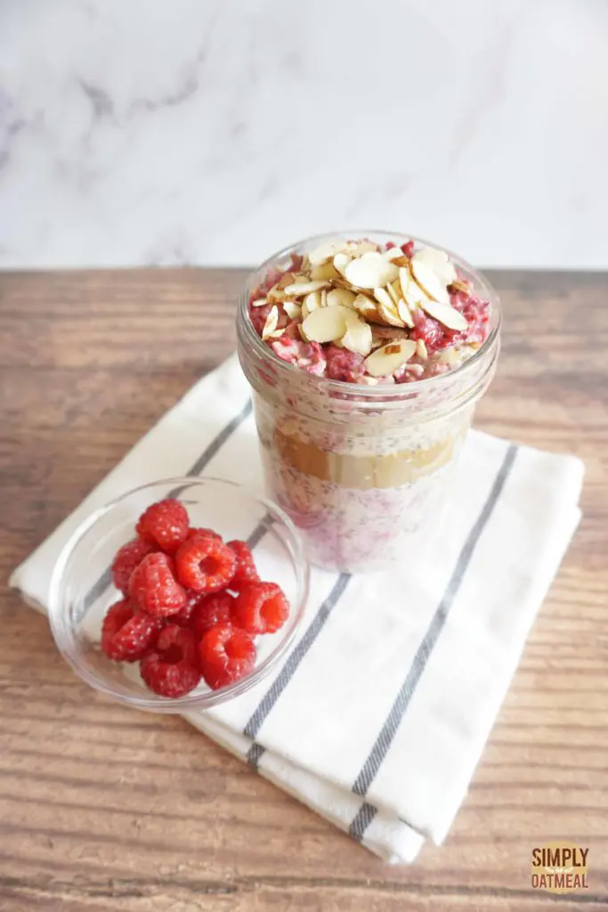 Raspberry almond overnight oats with a side of fresh raspberries and toasted almonds