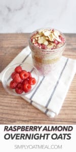Tall glass jar filled with a serving of fresh raspberry and almond overnight oats