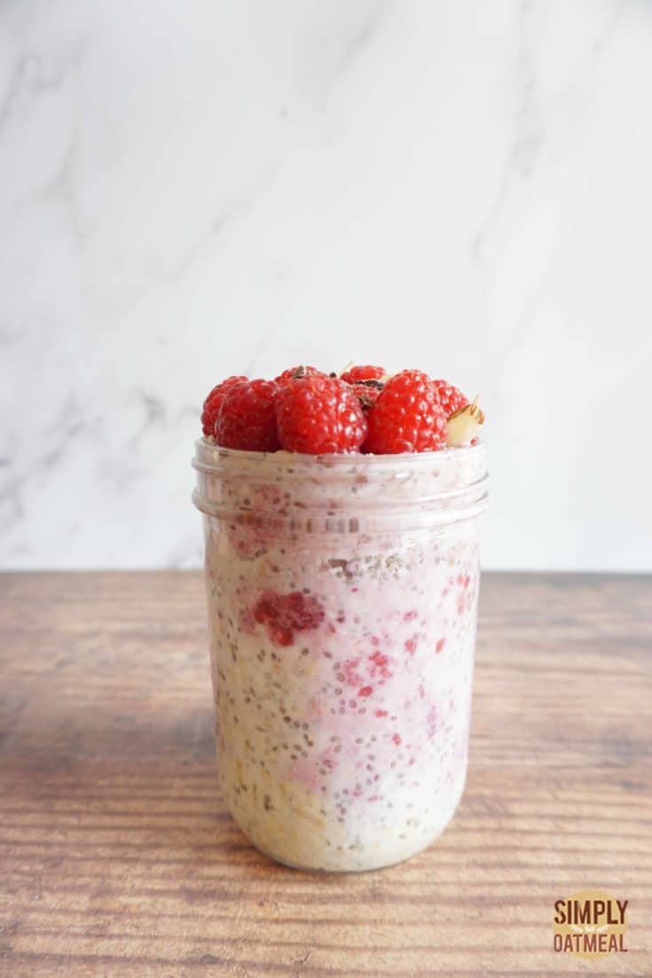Single serving of raspberry chia overnight oats in a tall glass jar
