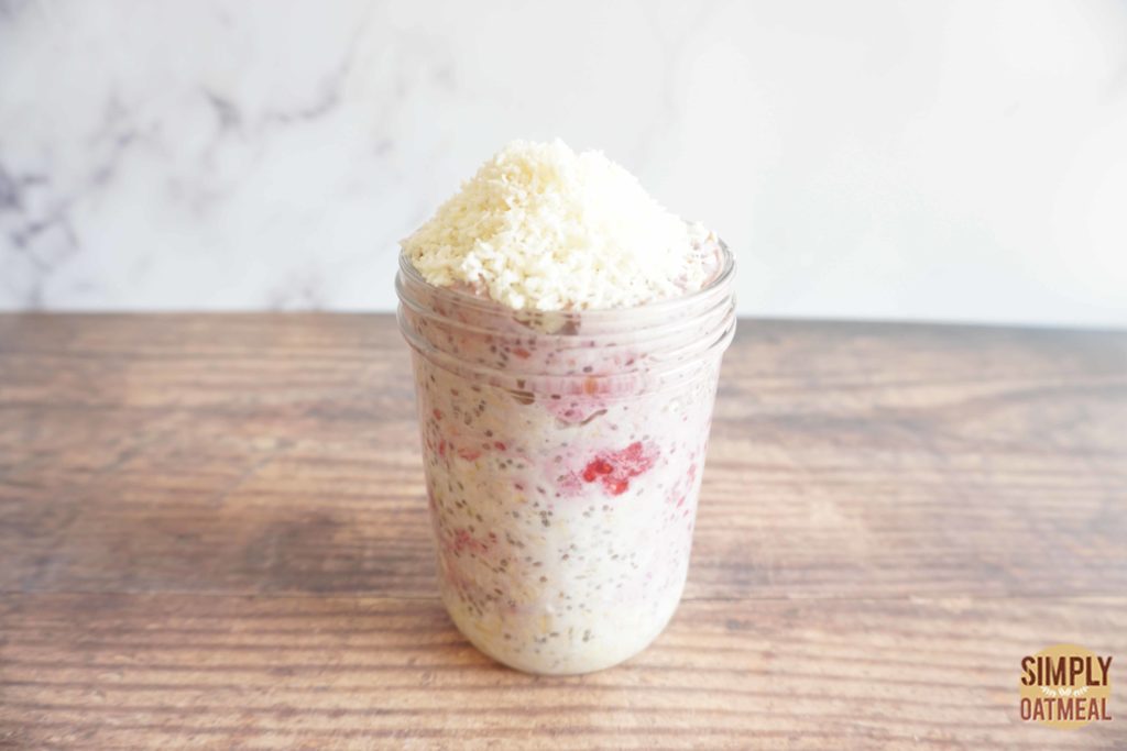 Raspberry coconut overnight oats topped with a pile of unsweetened shredded coconut