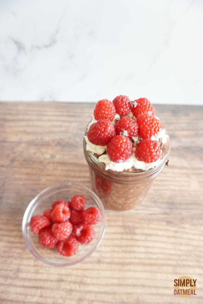 Serving of raspberry mocha overnight oats with fresh raspberries on the side.