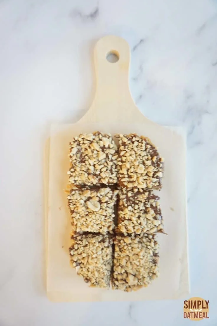 No bake chocolate peanut butter fudge oatmeal bars on a wood cutting board