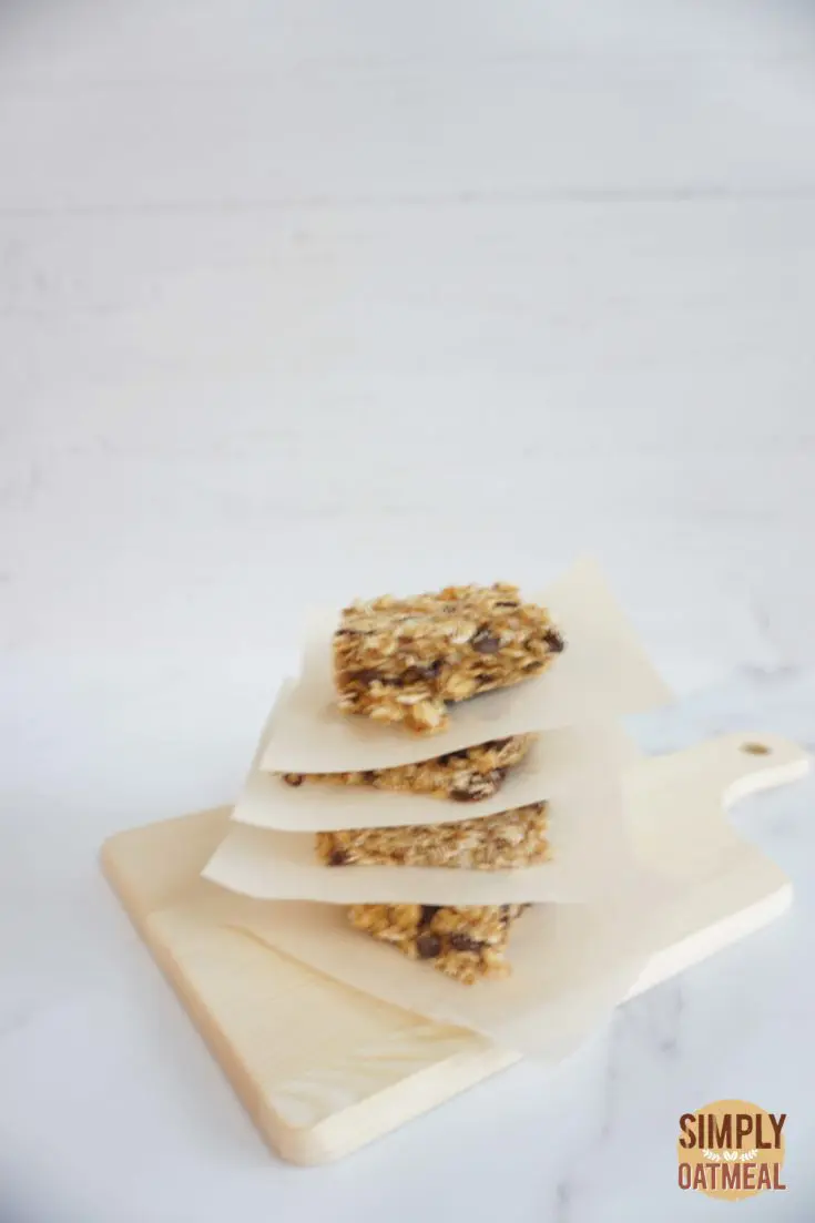 No bake oatmeal raisin bars stacked on top of each other with parchment paper in between
