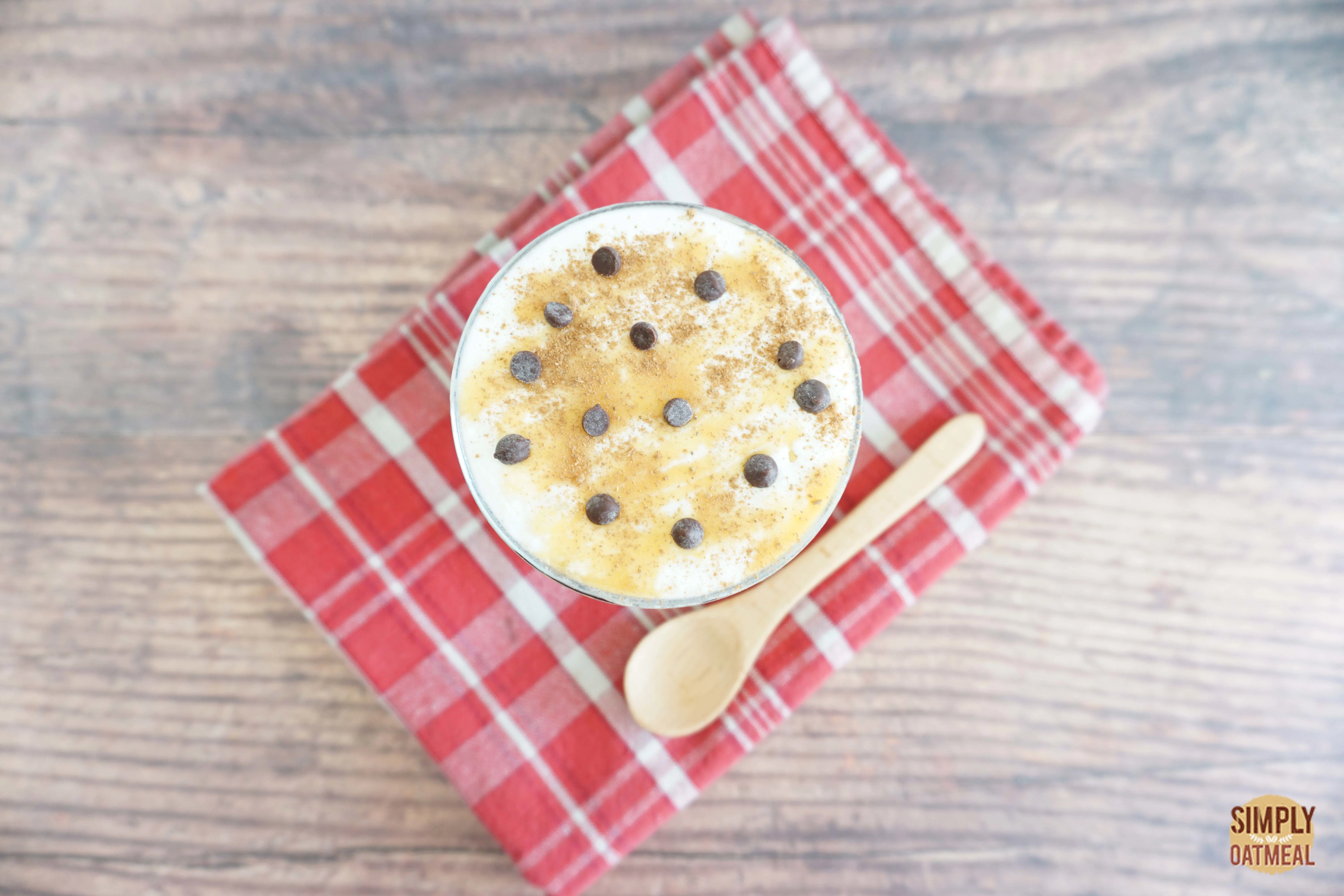 Caramel macchiato overnight oats topped with milk froth, caramel sauce, mini chocolate chips and a sprinkle of cinnamon.