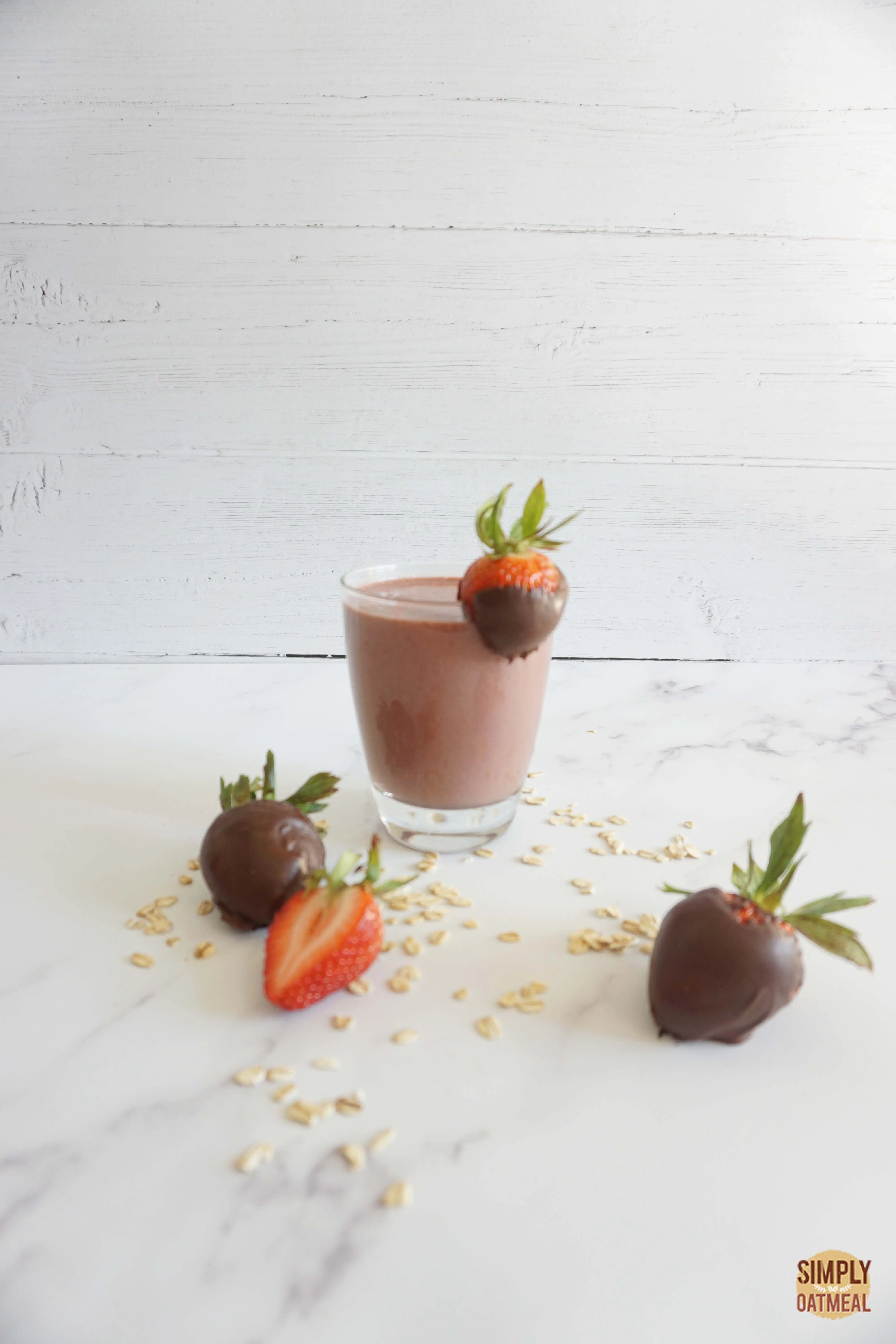 Single serving of chocolate covered strawberry oatmeal smoothie in a glass cup