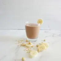 Single serving of chocolate peanut butter banana oatmeal smoothie in a glass cup