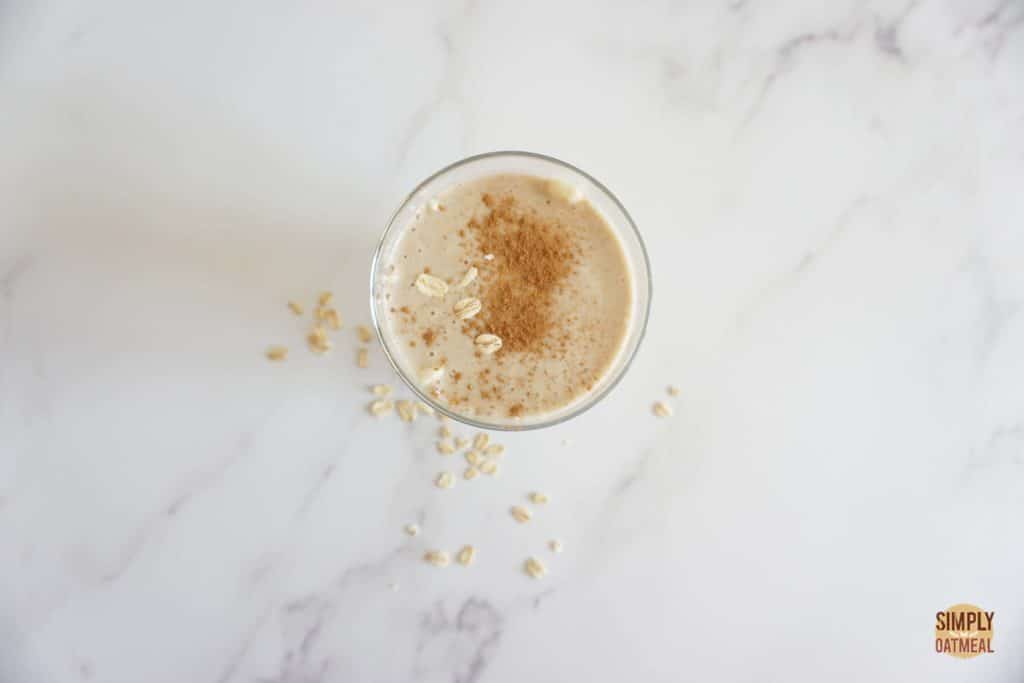 Cinnamon roll oatmeal smoothie topped with a sprinkle of cinnamon