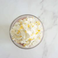 Lemon raspberry overnight oats topped with whipped cream, lemon zest and fresh vanilla bean.