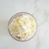 Lemon raspberry overnight oats topped with whipped cream, lemon zest and fresh vanilla bean.