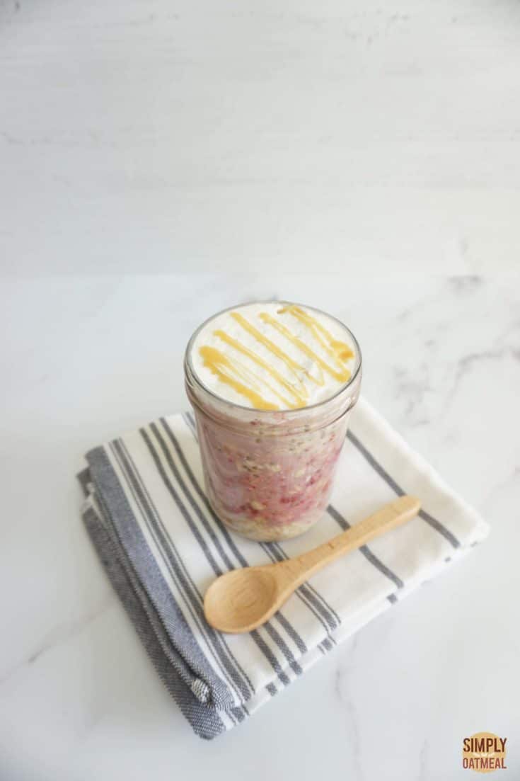 Single serving of maple raspberry overnight oats in a tall glass cup