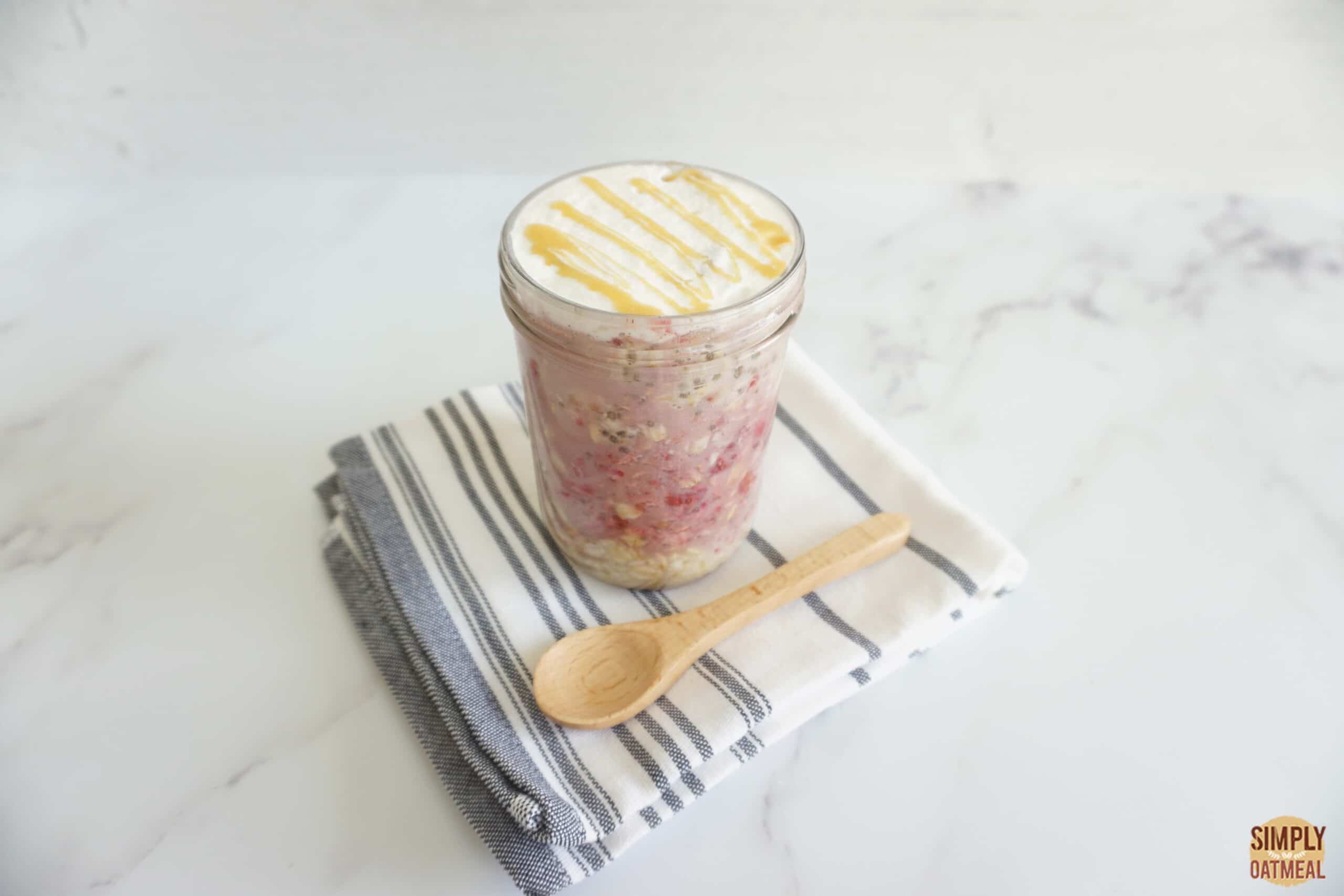 Mason jar filled with a single serving of maple raspberry overnight oats.