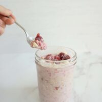 Spoonful of raspberry white chocolate overnight oats taken from a glass bowl