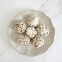 6 no bake almond joy oatmeal balls on a round plate with scalloped edges