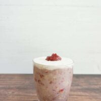 Strawberry pink drink overnight oats served in a tall glass jar.
