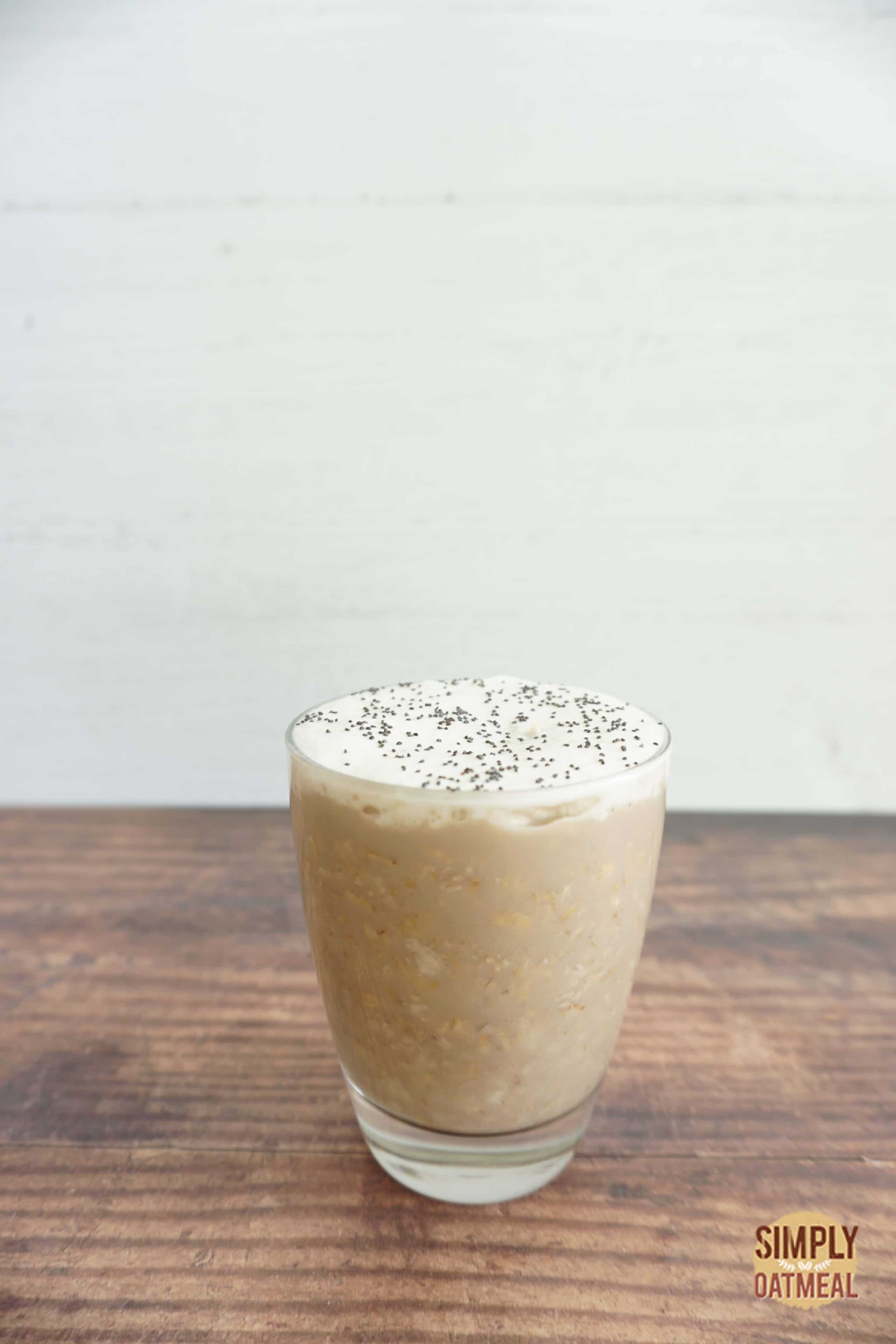 Serving of vanilla latte overnight oats in a glass jar topped with fresh vanilla bean.