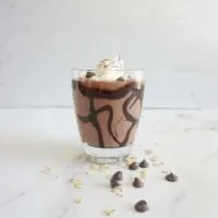 Single serving of vegan chocolate mousse oatmeal smoothie in a glass cup.