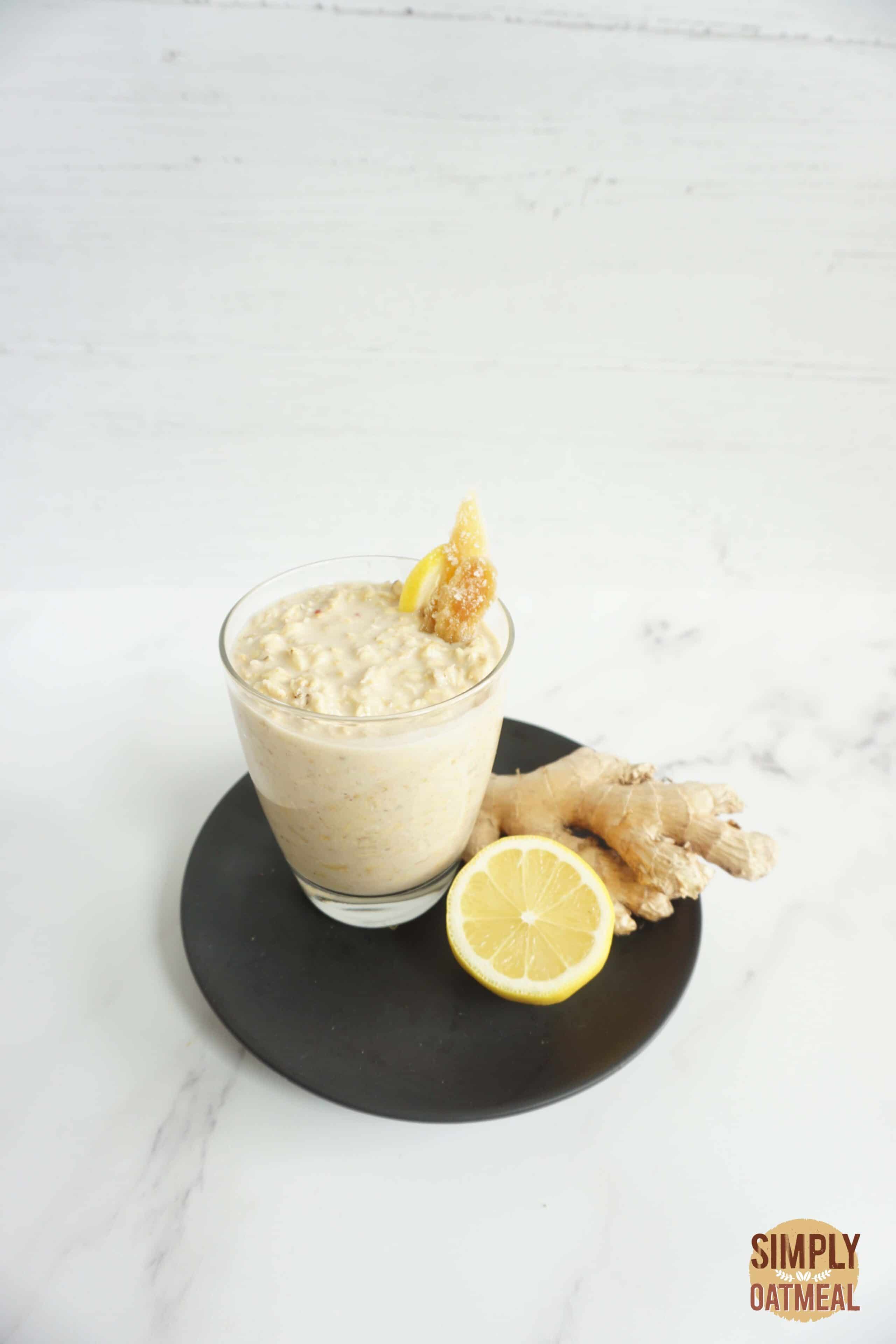 Serving of gingerade lemonade overnight oats in a glass cup and topped with candied ginger and lemon zest