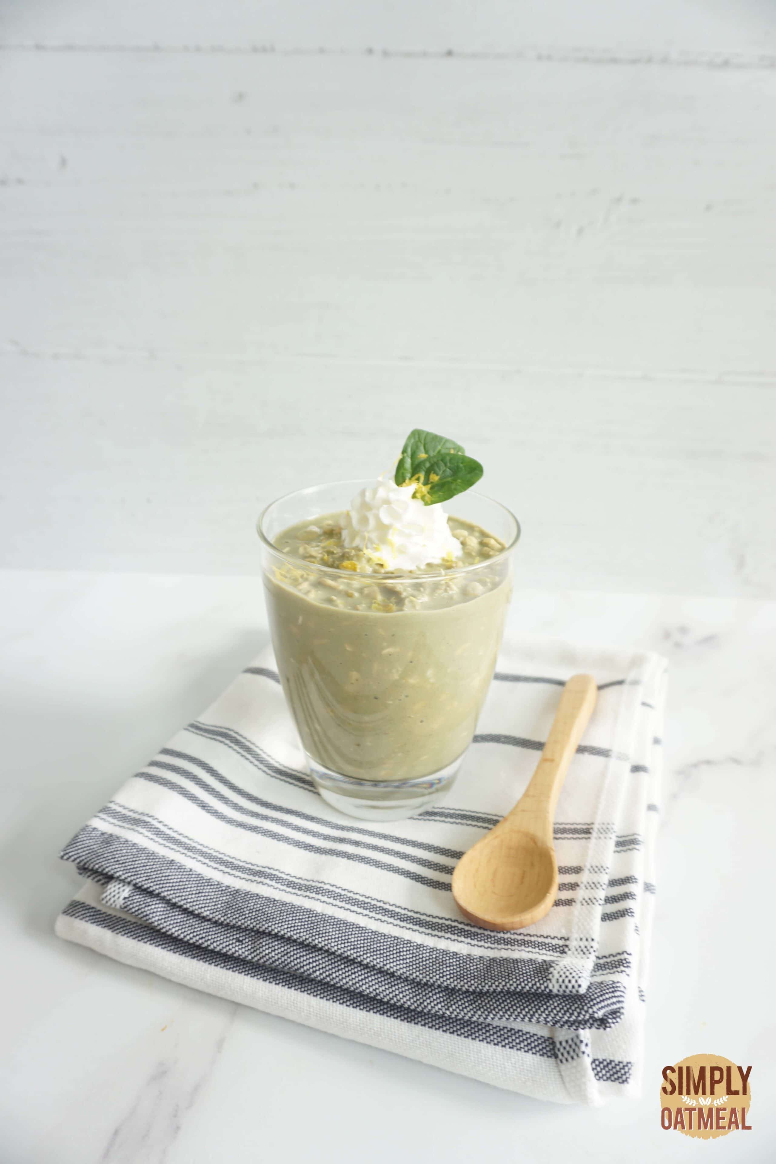 Green tea lemonade overnight oats served in a glass cup with sliced lemon and macha powder