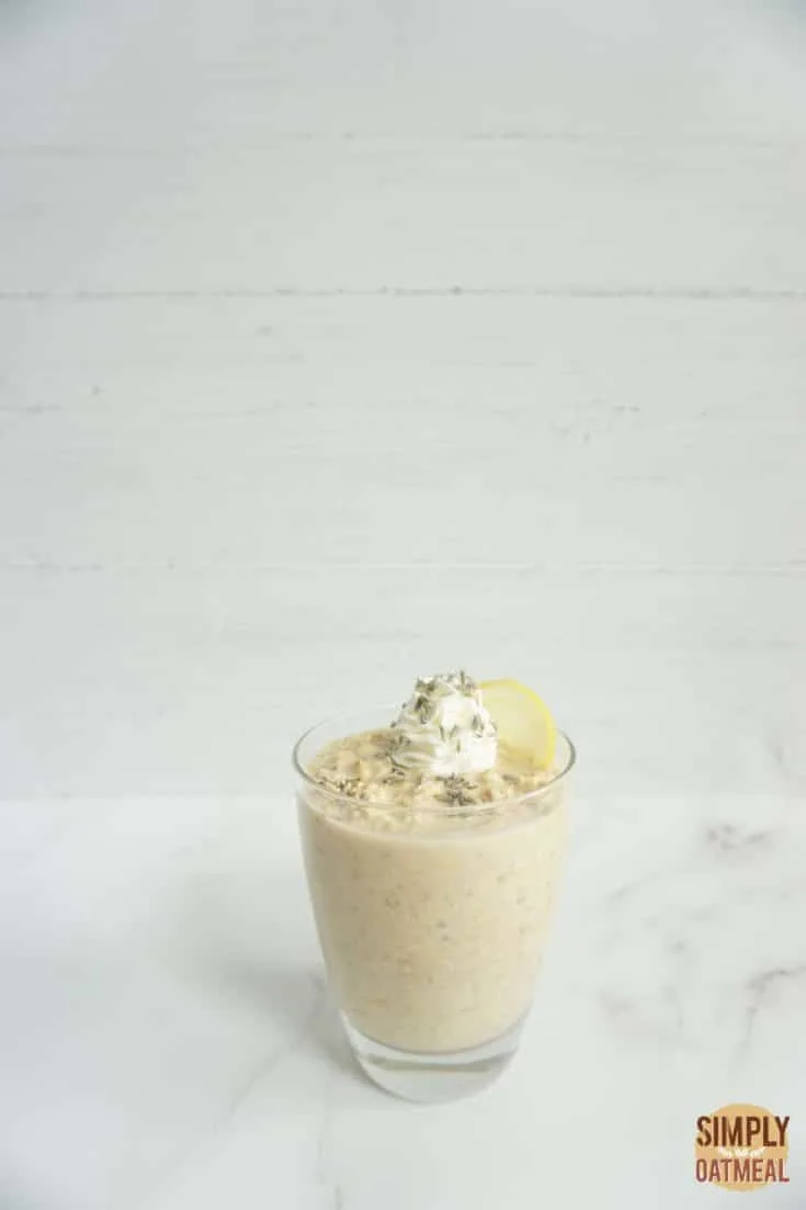 Lavender lemonade overnight oats served in a glass cup with fresh lavender flowers on top